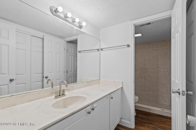 bathroom featuring hardwood / wood-style floors, a textured ceiling, vanity, and toilet