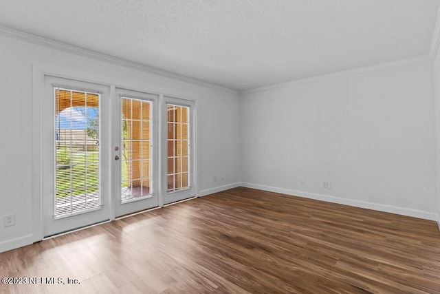 spare room featuring wood-type flooring, a textured ceiling, and ornamental molding