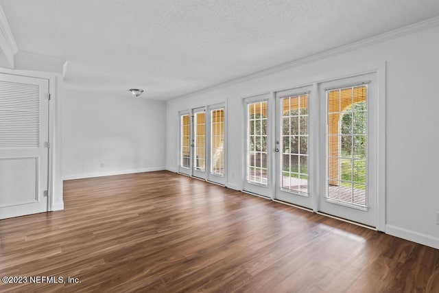 empty room featuring a textured ceiling, crown molding, and dark hardwood / wood-style flooring