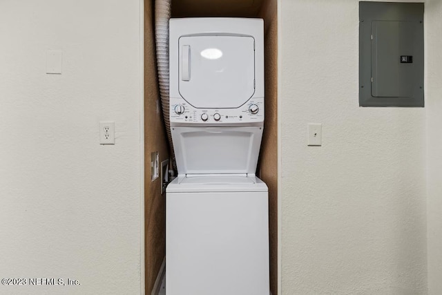 laundry room featuring stacked washing maching and dryer and electric panel