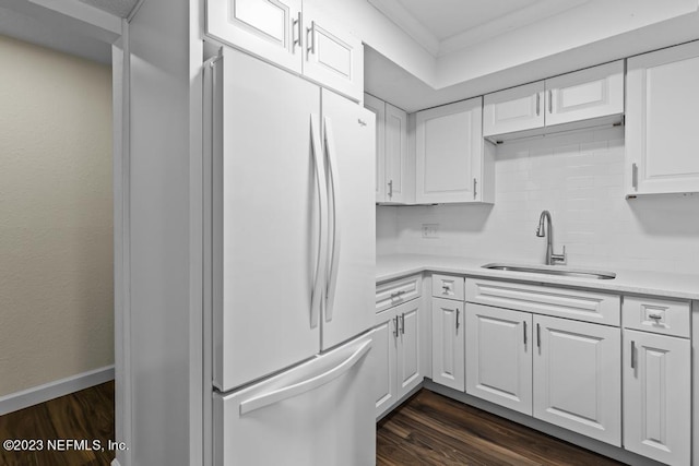 kitchen with dark hardwood / wood-style floors, sink, white cabinets, white fridge, and backsplash