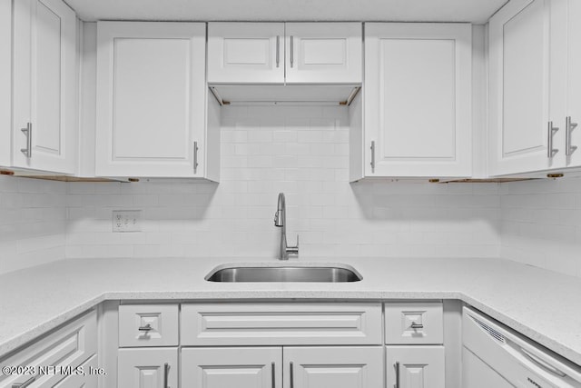 kitchen featuring white cabinets, dishwasher, sink, and decorative backsplash