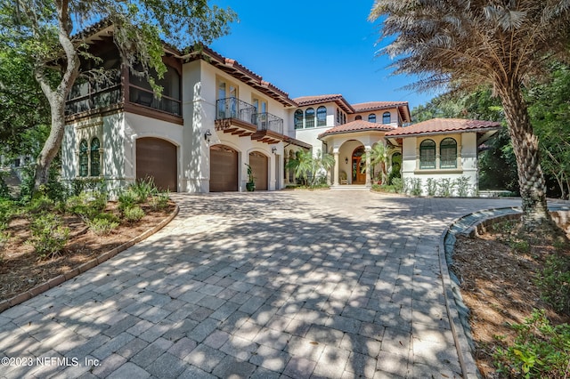 mediterranean / spanish-style home featuring a balcony and a garage