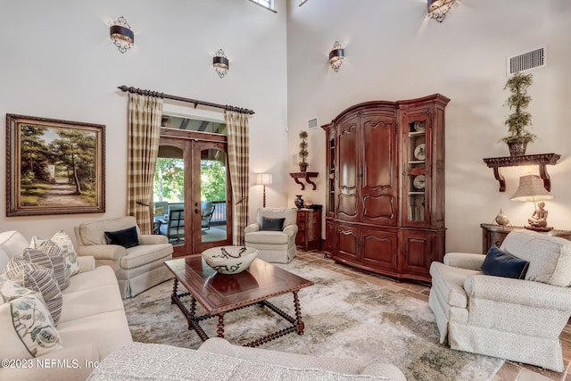 living room featuring a towering ceiling and french doors