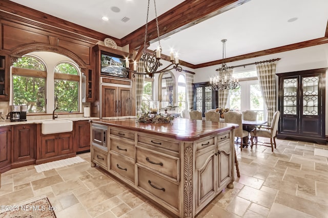 kitchen with butcher block countertops, sink, a center island, and a healthy amount of sunlight