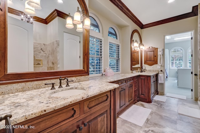 bathroom with an inviting chandelier, vanity, and crown molding