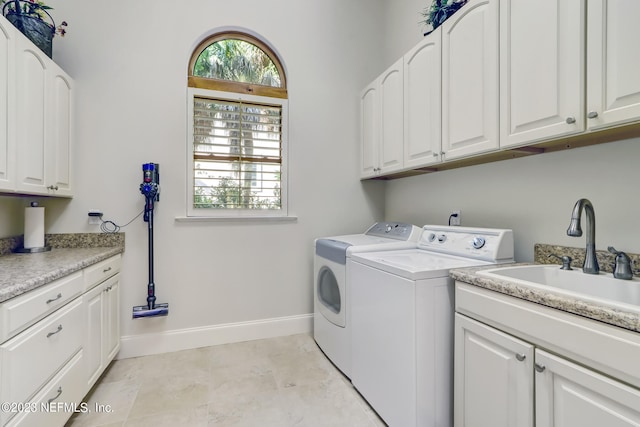 laundry room featuring independent washer and dryer, cabinets, and sink