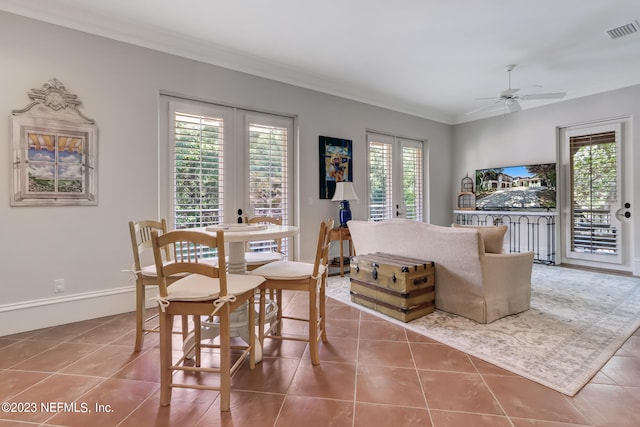 dining room with ceiling fan, tile patterned flooring, and ornamental molding