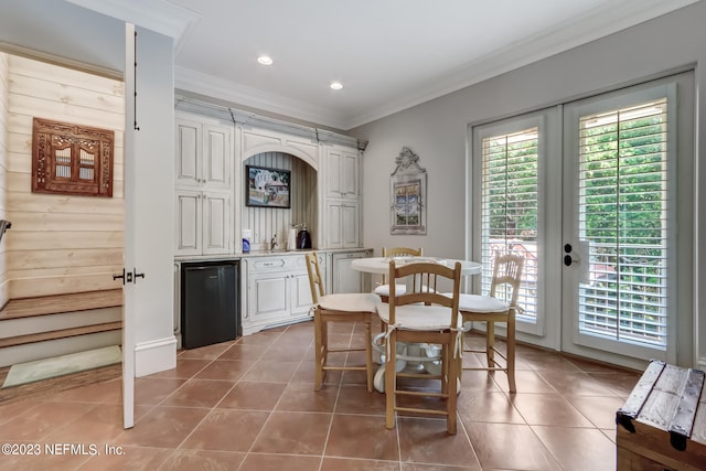 dining area featuring french doors, ornamental molding, and tile patterned floors