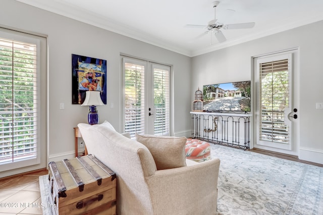 living room featuring a healthy amount of sunlight, ceiling fan, tile patterned floors, and crown molding