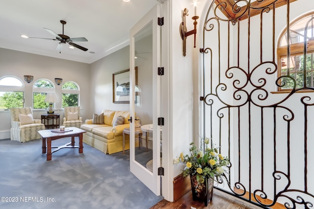 living room with hardwood / wood-style flooring, crown molding, and ceiling fan