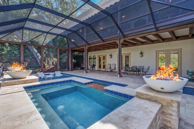 view of pool with an outdoor fire pit, a patio area, and a lanai