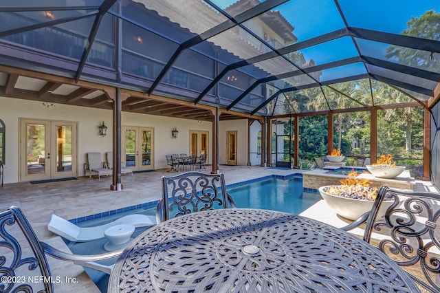 view of swimming pool featuring glass enclosure, a patio, and french doors