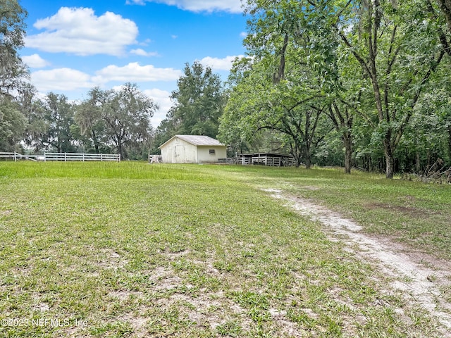 view of yard featuring a rural view and an outbuilding