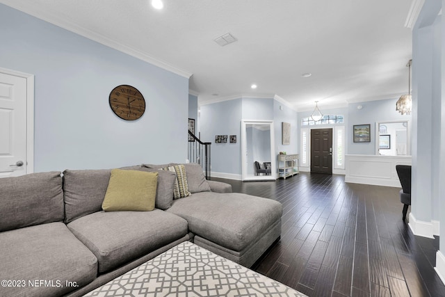 living room with ornamental molding, dark wood-type flooring, and a notable chandelier