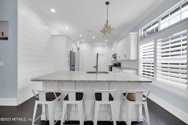 kitchen featuring dark hardwood / wood-style flooring, white cabinetry, sink, and hanging light fixtures