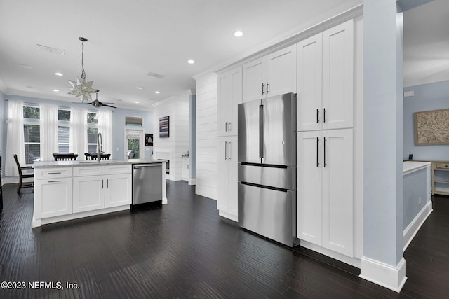 kitchen featuring sink, ceiling fan, decorative light fixtures, white cabinetry, and stainless steel appliances