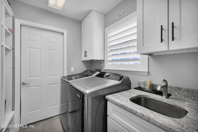 washroom featuring washer and clothes dryer, light tile patterned floors, cabinets, and sink