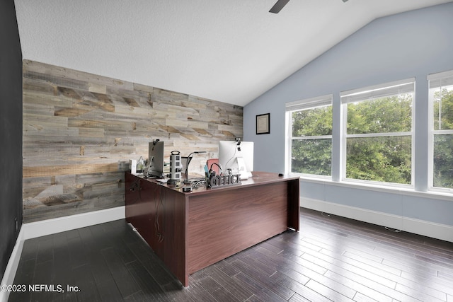 unfurnished office featuring vaulted ceiling, wood walls, ceiling fan, and dark hardwood / wood-style floors