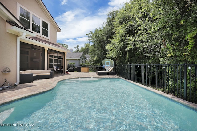 view of swimming pool featuring outdoor lounge area, ceiling fan, and a patio