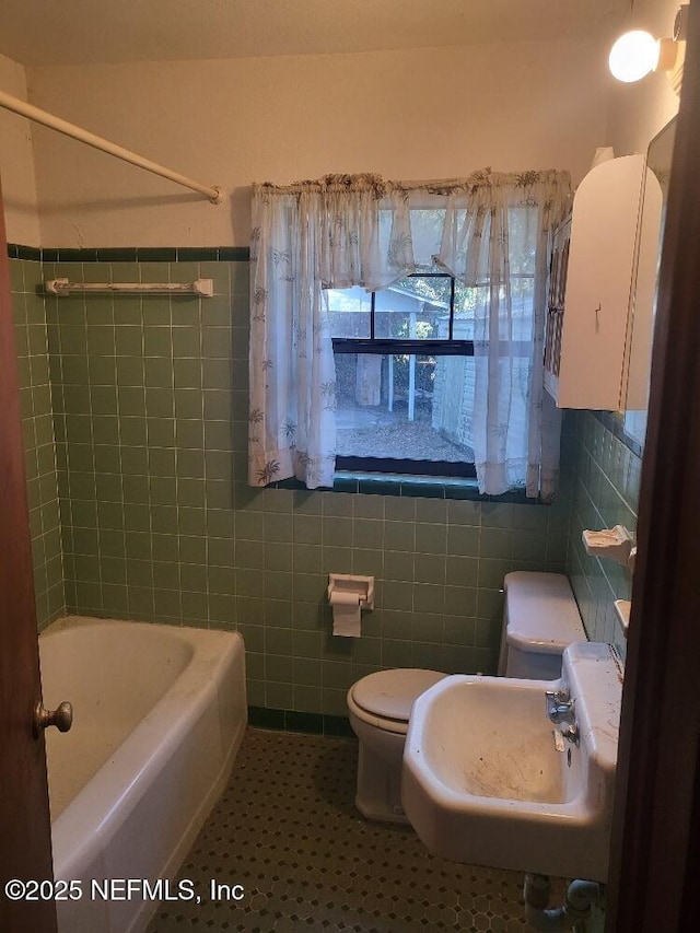 full bathroom featuring sink, toilet, tile walls, and shower / bath combination