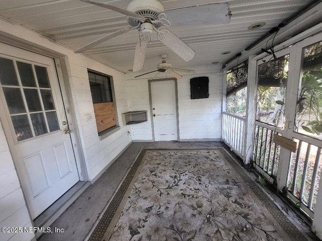 unfurnished sunroom featuring electric panel and ceiling fan