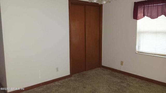 unfurnished bedroom featuring carpet and a closet