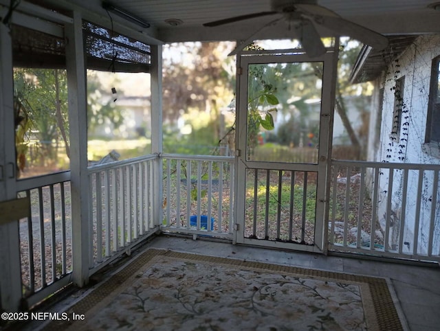 unfurnished sunroom featuring ceiling fan