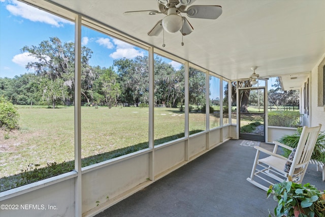 unfurnished sunroom featuring ceiling fan