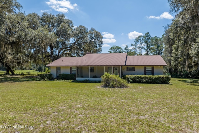 view of front of home with a front yard and a sunroom