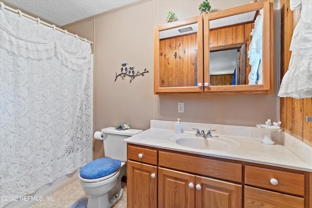 bathroom with toilet, vanity, and a textured ceiling