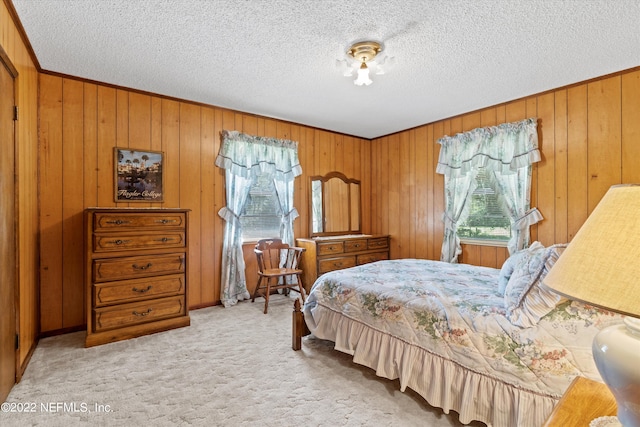 carpeted bedroom with wooden walls and a textured ceiling