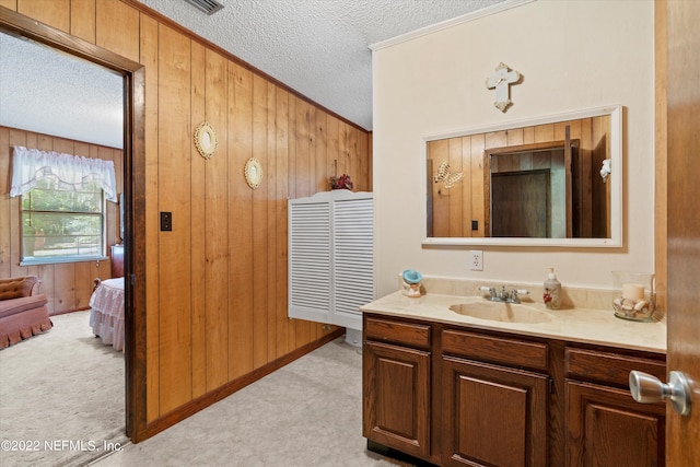 bathroom featuring wooden walls, vanity, and a textured ceiling