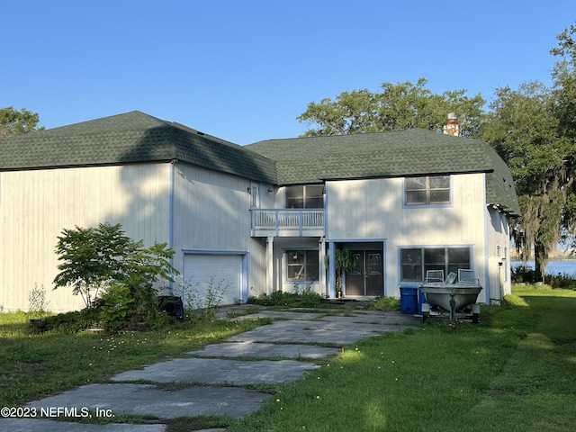 view of front of house with a balcony and a front yard