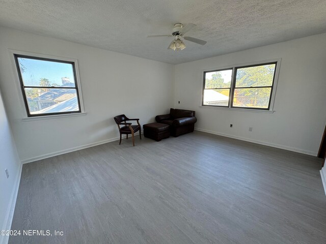 unfurnished room with hardwood / wood-style flooring, ceiling fan, and a textured ceiling