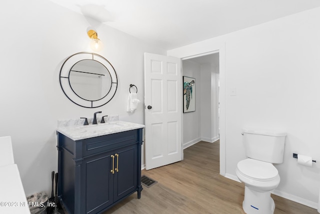 bathroom featuring toilet, wood-type flooring, and vanity