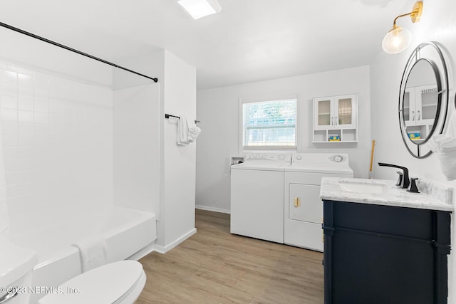 full bathroom with toilet, hardwood / wood-style floors, washer and dryer, bathtub / shower combination, and vanity