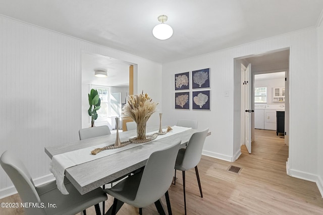 dining space with washer and clothes dryer, light wood-type flooring, and crown molding