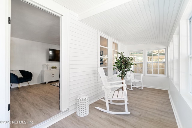 sunroom / solarium featuring beamed ceiling