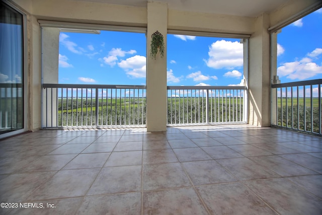 unfurnished sunroom featuring a water view