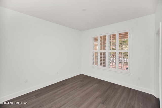 unfurnished room with dark wood-type flooring