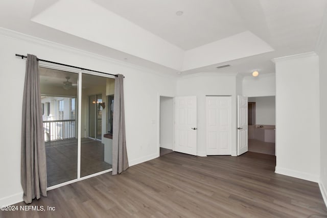 unfurnished room with crown molding, dark wood-type flooring, and a tray ceiling