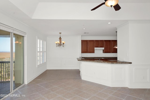 kitchen with light tile patterned floors, crown molding, ceiling fan with notable chandelier, decorative light fixtures, and kitchen peninsula