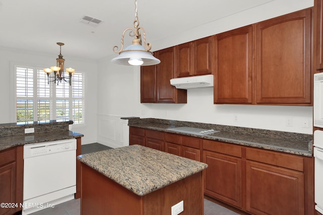 kitchen featuring decorative light fixtures, ornamental molding, a kitchen island, stone counters, and white appliances