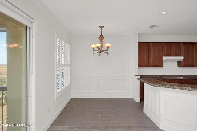 interior space with dark tile patterned flooring and a chandelier