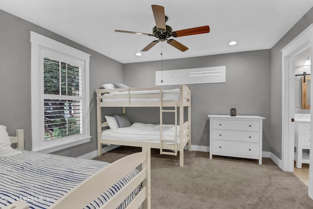 carpeted bedroom featuring ceiling fan and ensuite bath