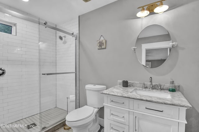 bathroom with a shower with door, vanity, and toilet