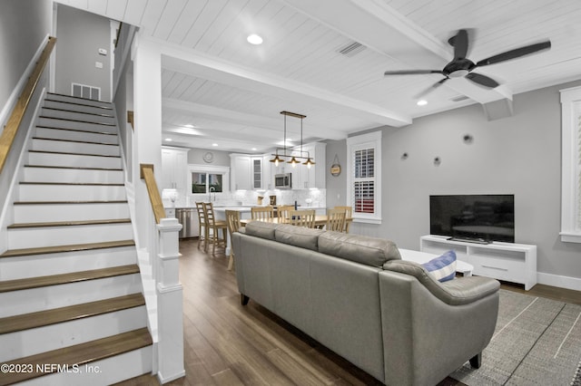 living room featuring ceiling fan, dark wood-type flooring, wood ceiling, and beam ceiling