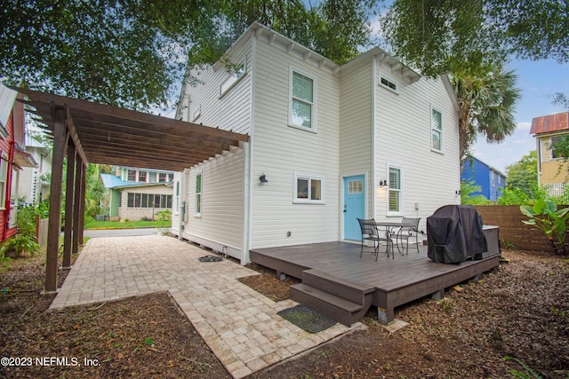 back of property with a pergola and a deck