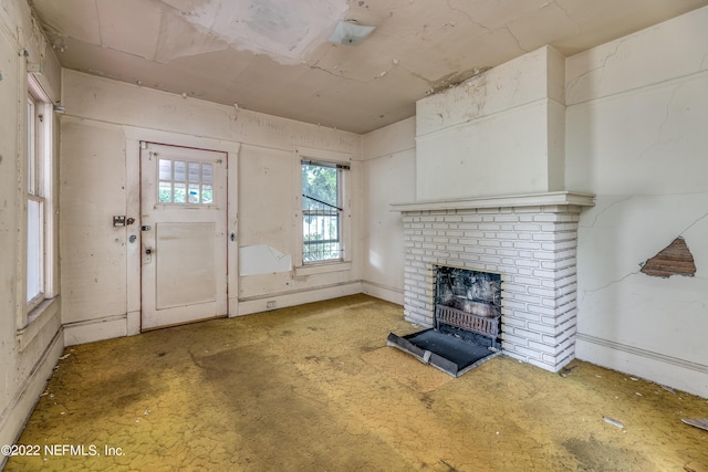 unfurnished living room featuring a brick fireplace